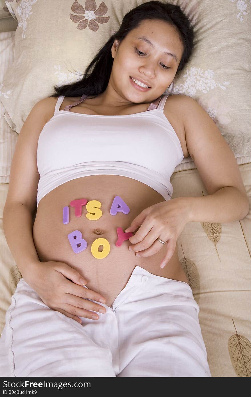 Pregnant woman playing with letters on her belly. Pregnant woman playing with letters on her belly