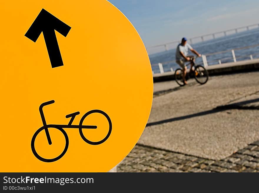 Yellow cycleway sign and a blurred cycler. Yellow cycleway sign and a blurred cycler