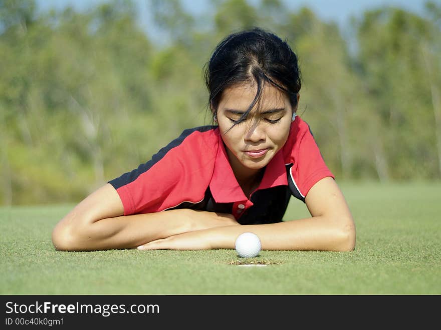 Young, female golf player and a golf ball that almost made it. Young, female golf player and a golf ball that almost made it.