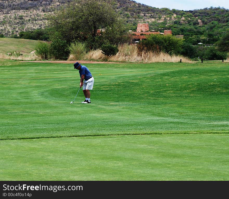 Golfer preparing to hit the ball onto the green. Golfer preparing to hit the ball onto the green.