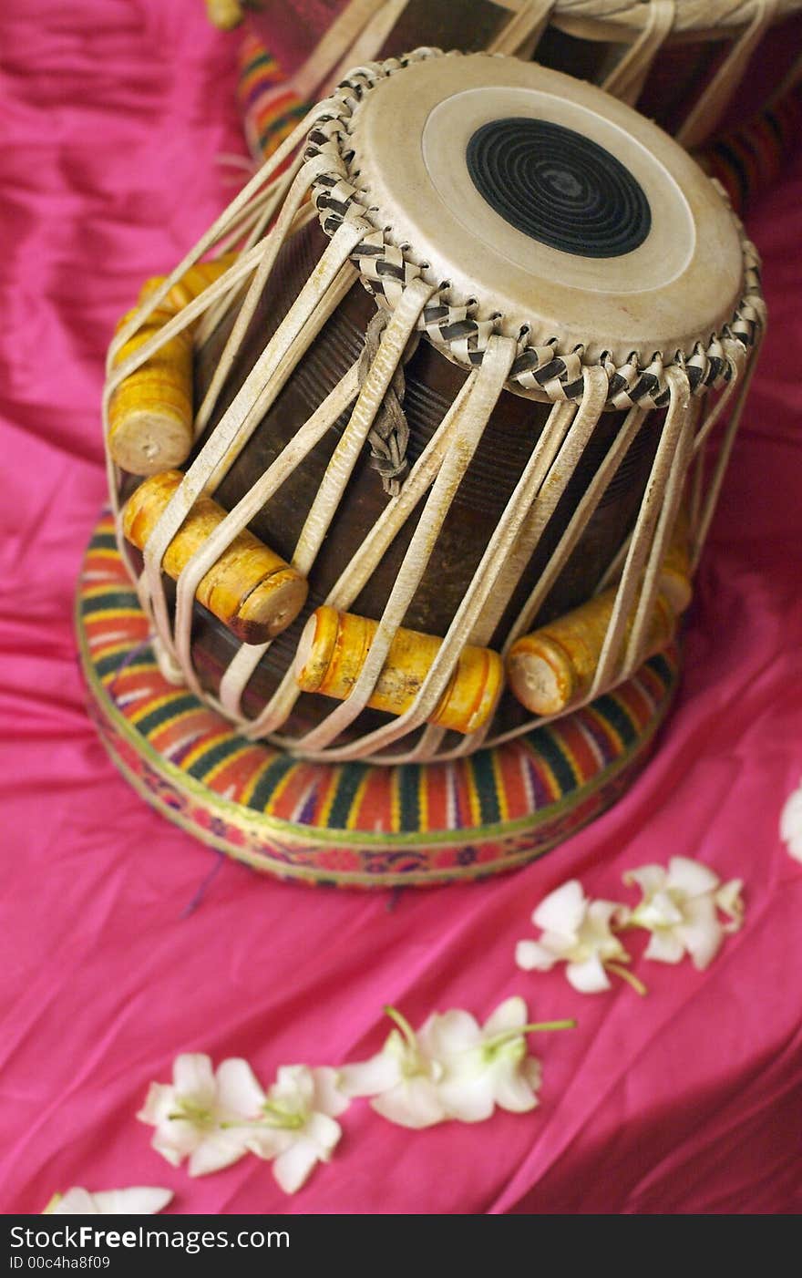 Detail of a drum on pink fabric with white orchids. Detail of a drum on pink fabric with white orchids.