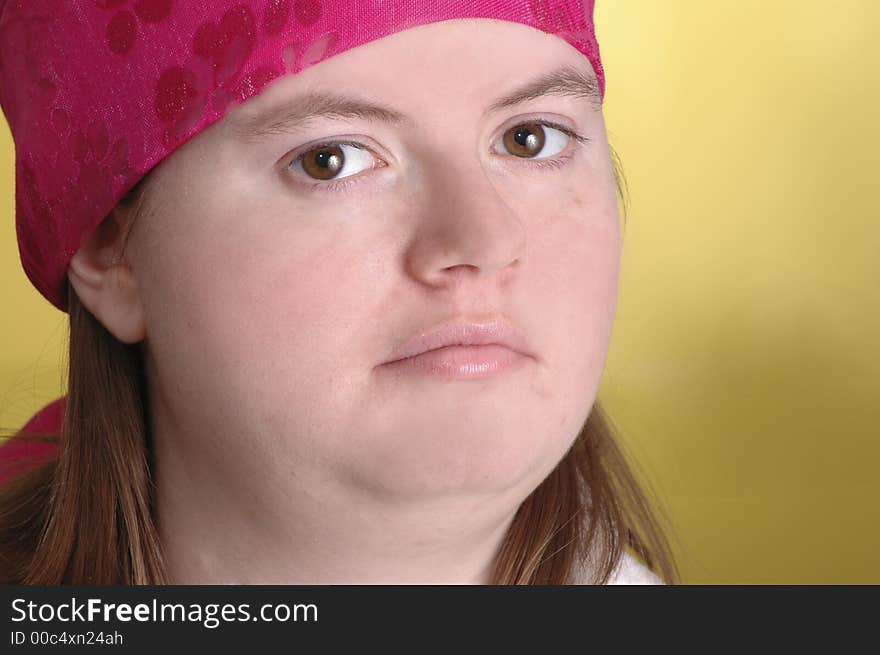 A woman wearing a pink scarf on her head. Yellow background. A woman wearing a pink scarf on her head. Yellow background.