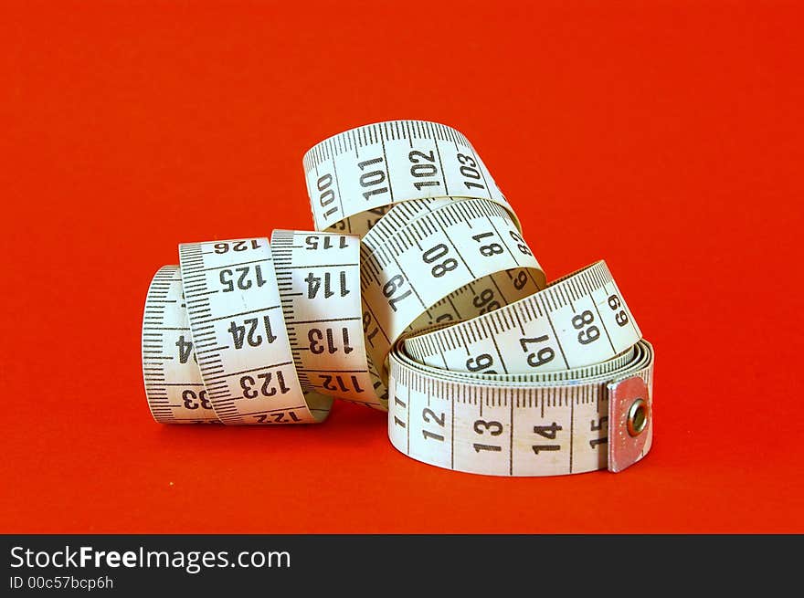 Measuring tape against bright red background. Measuring tape against bright red background