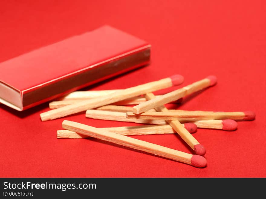 Red matches with red match box on red background. Studio picture. Red matches with red match box on red background. Studio picture