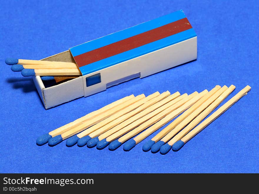 Blue matches with fitting box on blue background. Studio picture. Blue matches with fitting box on blue background. Studio picture