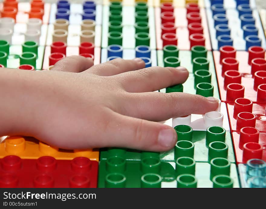 Hands of a child building blocks, lining them up in a row. Useful for a building concept.