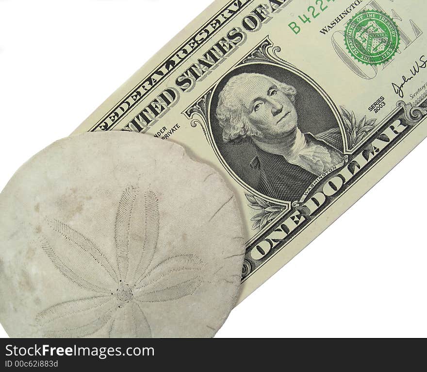 A slightly battered sand dollar rests on top of a U.S. dollar. A slightly battered sand dollar rests on top of a U.S. dollar.