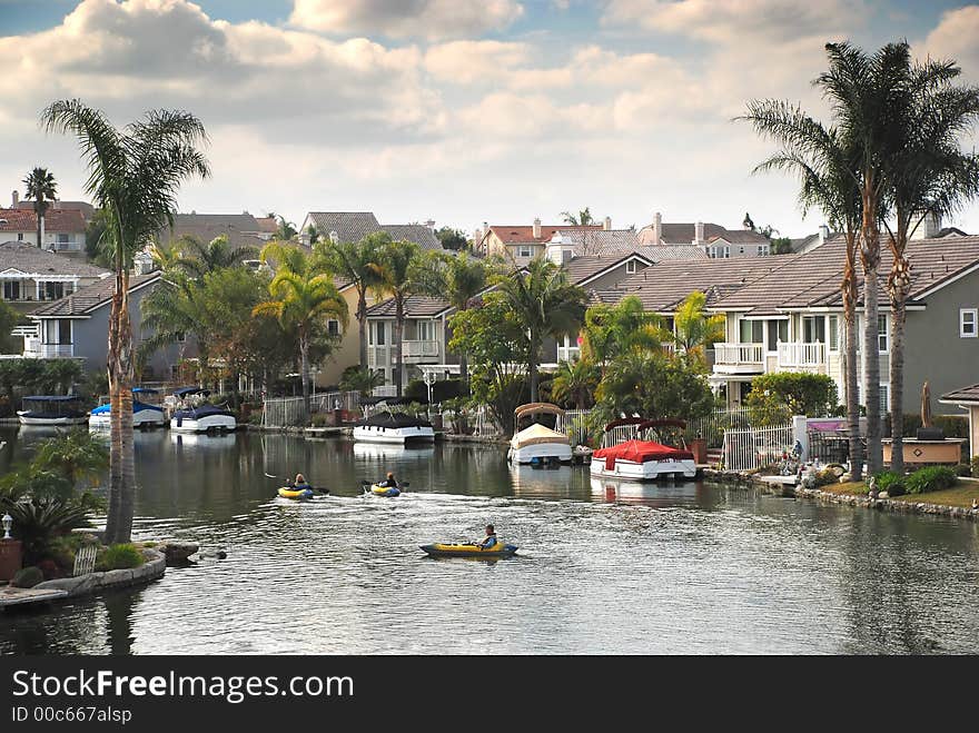 Three people kayak on a pretty lake with palm trees. Three people kayak on a pretty lake with palm trees.