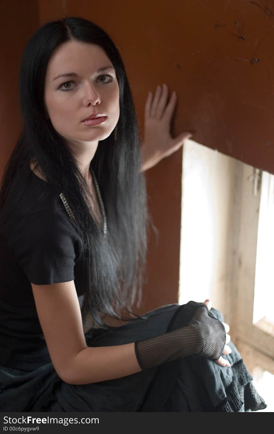 Portrait of young beautiful woman sitting near the window. Portrait of young beautiful woman sitting near the window