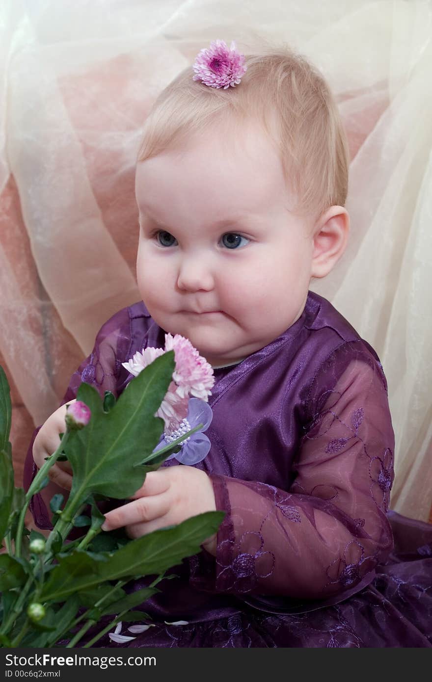 Smiling little cute girl sitting on the chair with flower in her hands. Smiling little cute girl sitting on the chair with flower in her hands