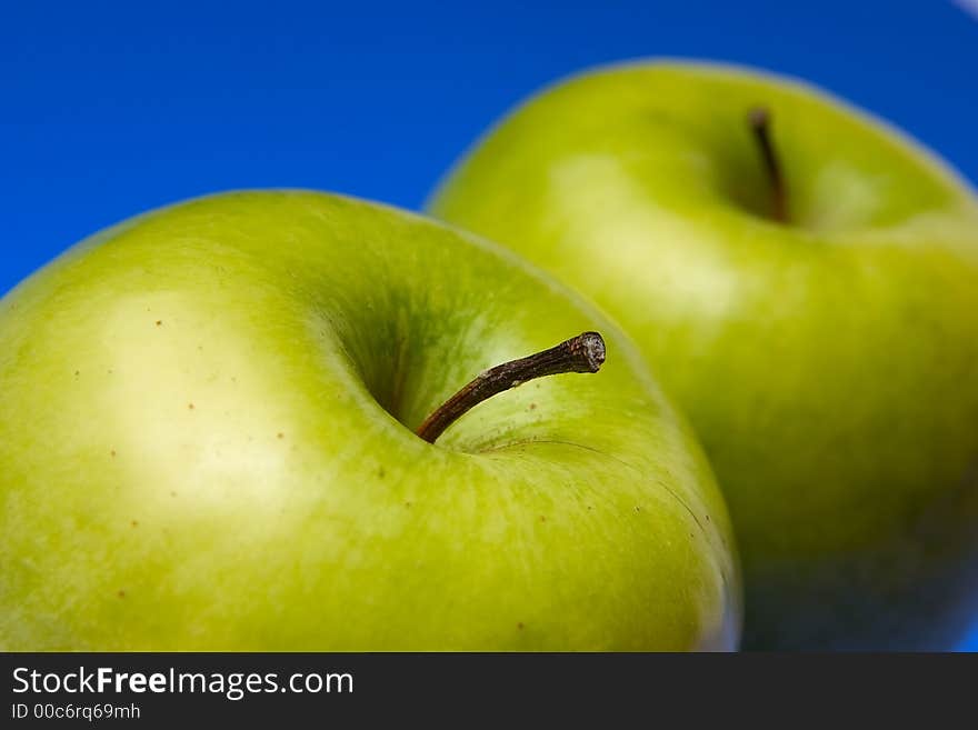 Appetizing apples of green color on a blue background