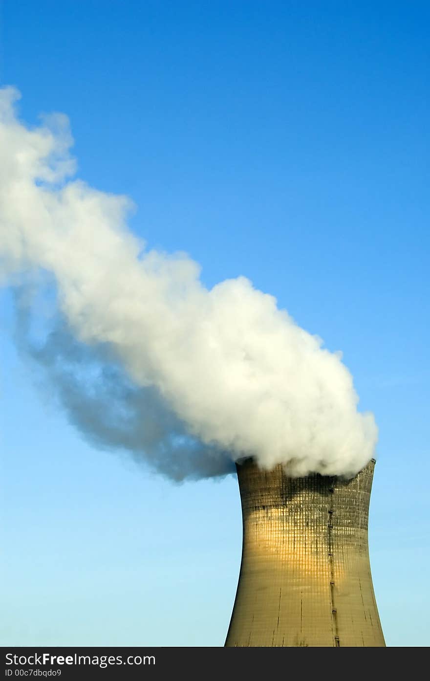 Generating station with big white smoke and blue sky