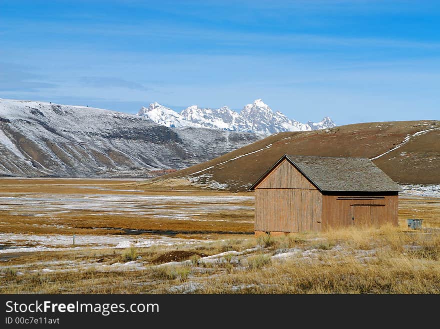 Barn With Snow Covered Mountains in the Background. Barn With Snow Covered Mountains in the Background