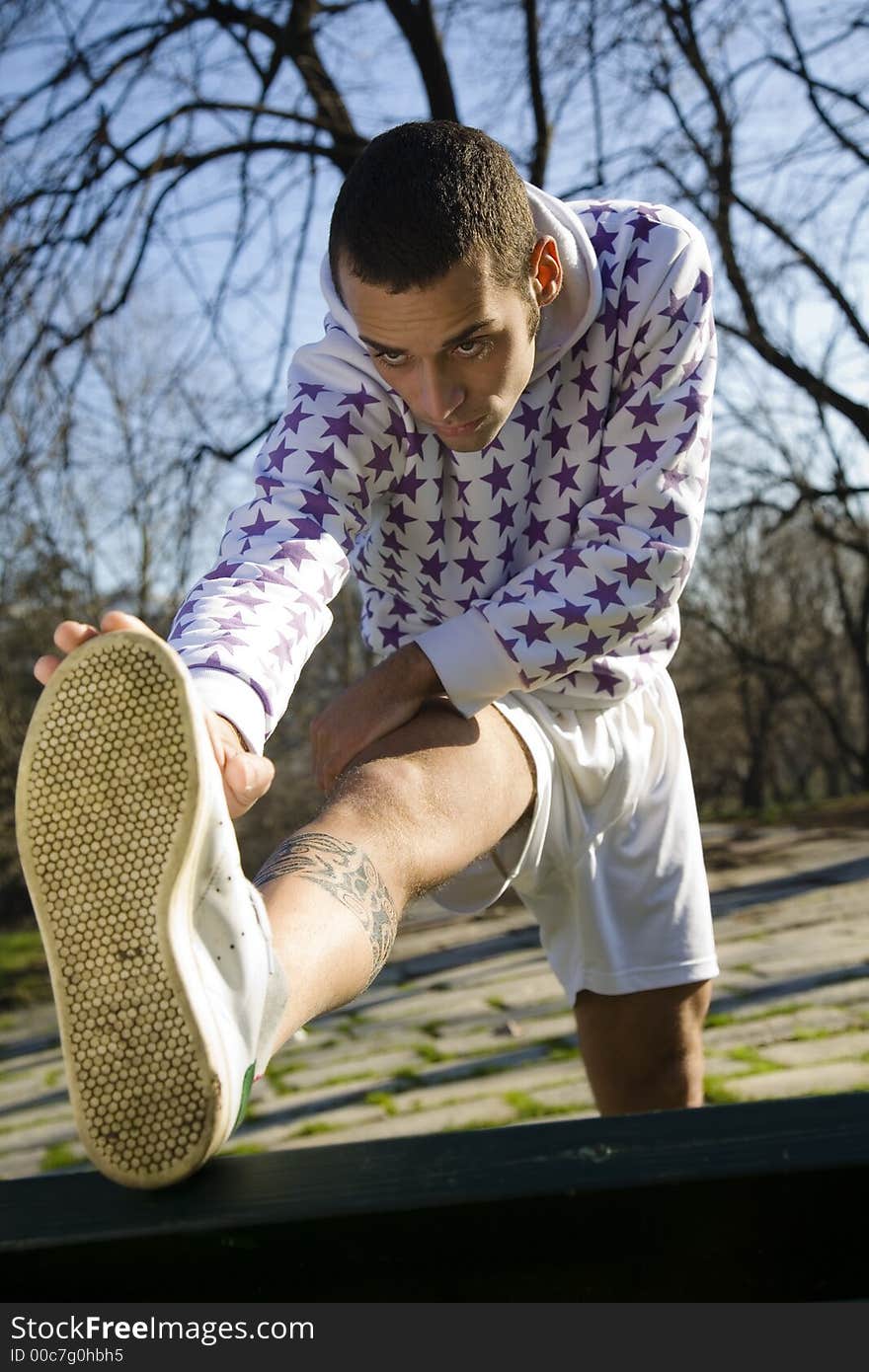 Healthy lifestyle: man doing stretching in a park. Healthy lifestyle: man doing stretching in a park