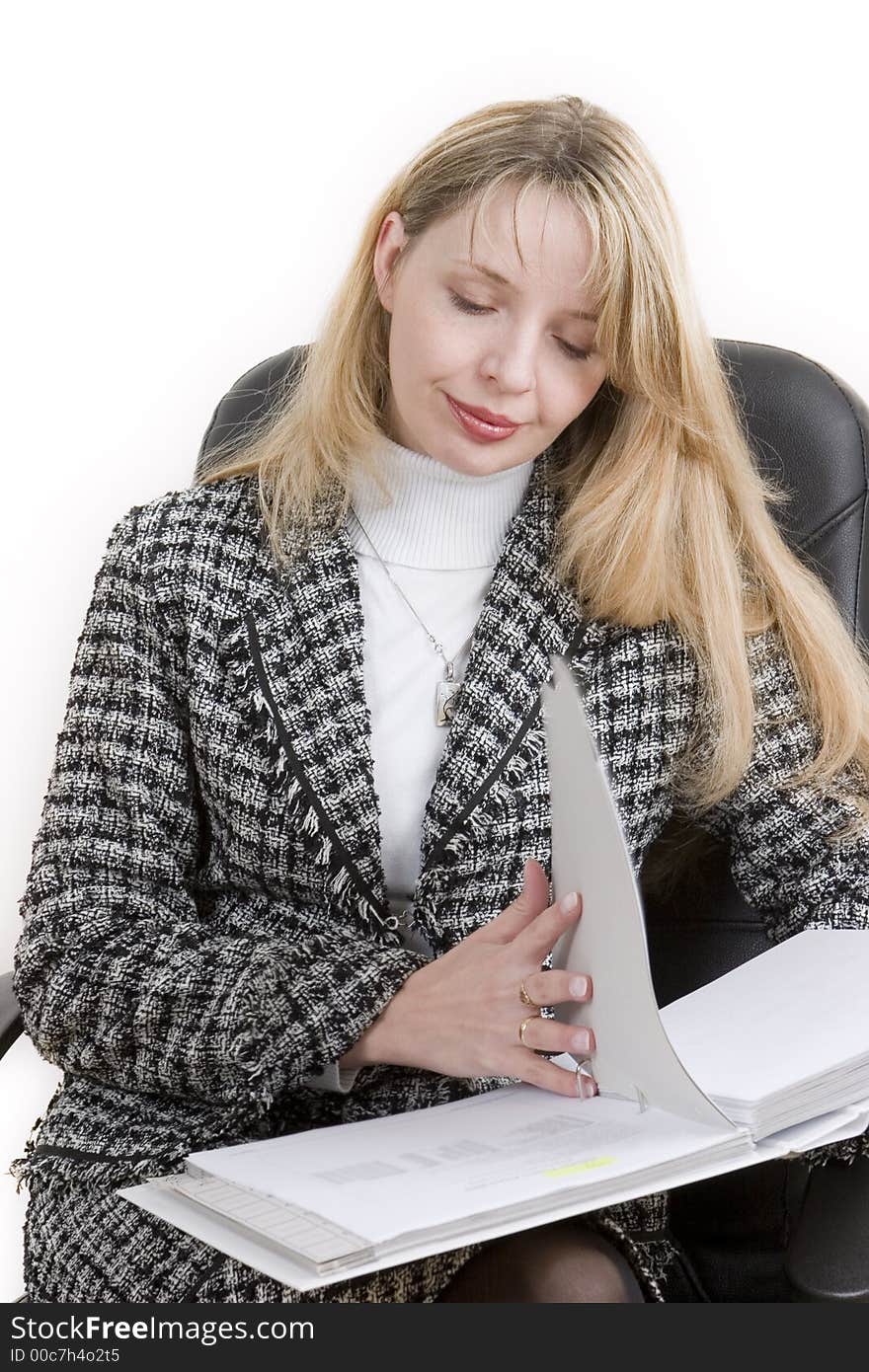 A business woman reading reading through a folder. A business woman reading reading through a folder