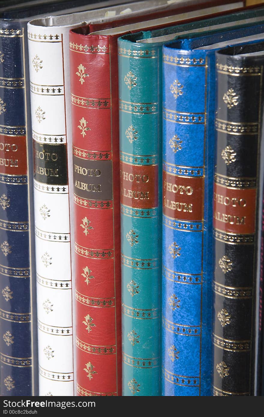 Row of multi-colored photo albums on the bookshelf. Row of multi-colored photo albums on the bookshelf