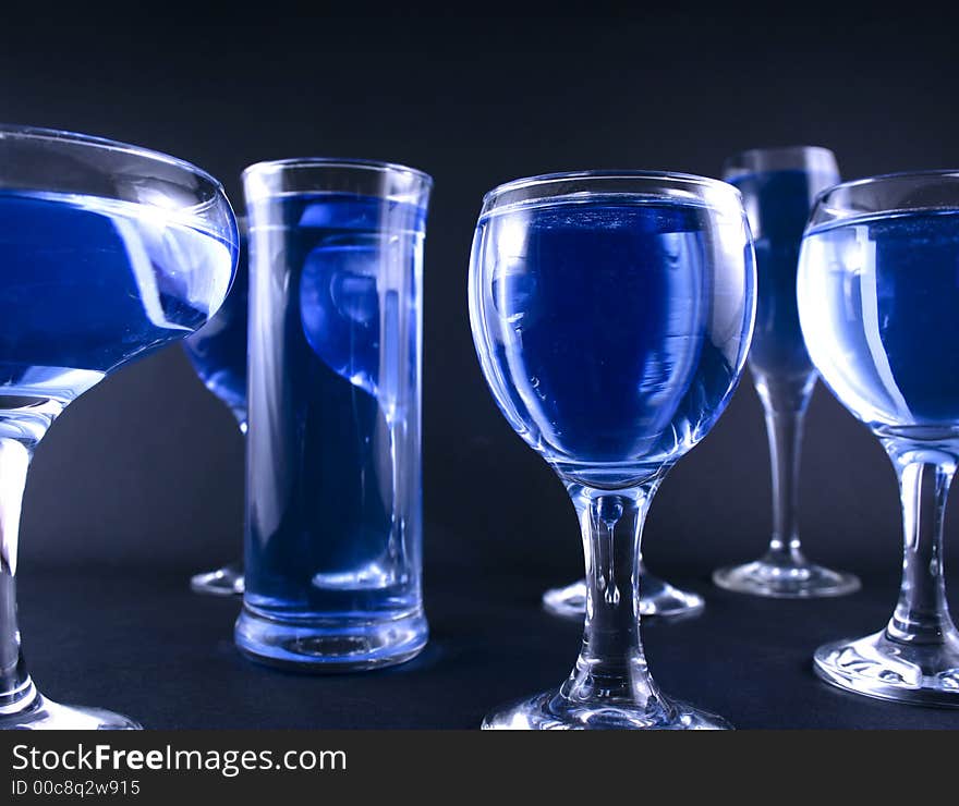 Glasses with a blue drink on a black background