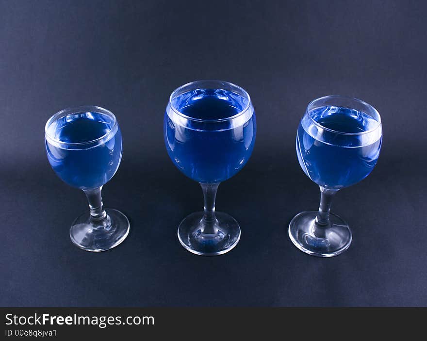 Glasses with a blue drink on a black background