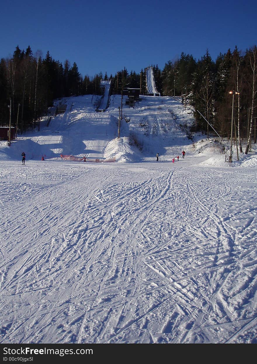 Three ski jumps on a hill.