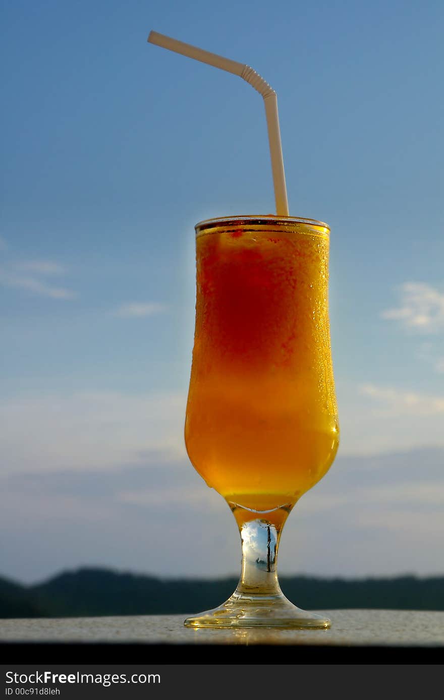 Glass of juice against blue sky