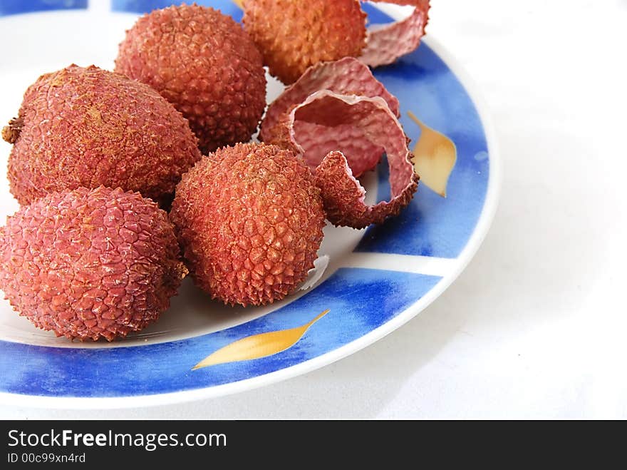 Lychees on a plate isolated against white background