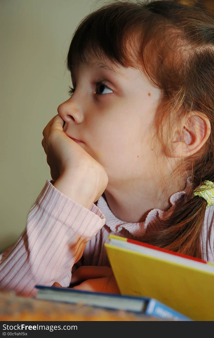 The small schoolgirl behind reading of books. The small schoolgirl behind reading of books