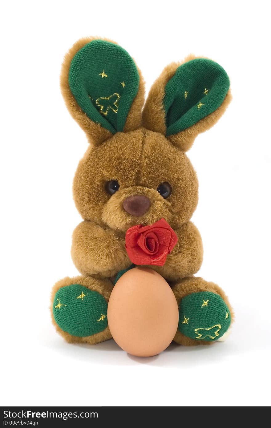 A fluffy toy bunny holding an egg. A fluffy toy bunny holding an egg