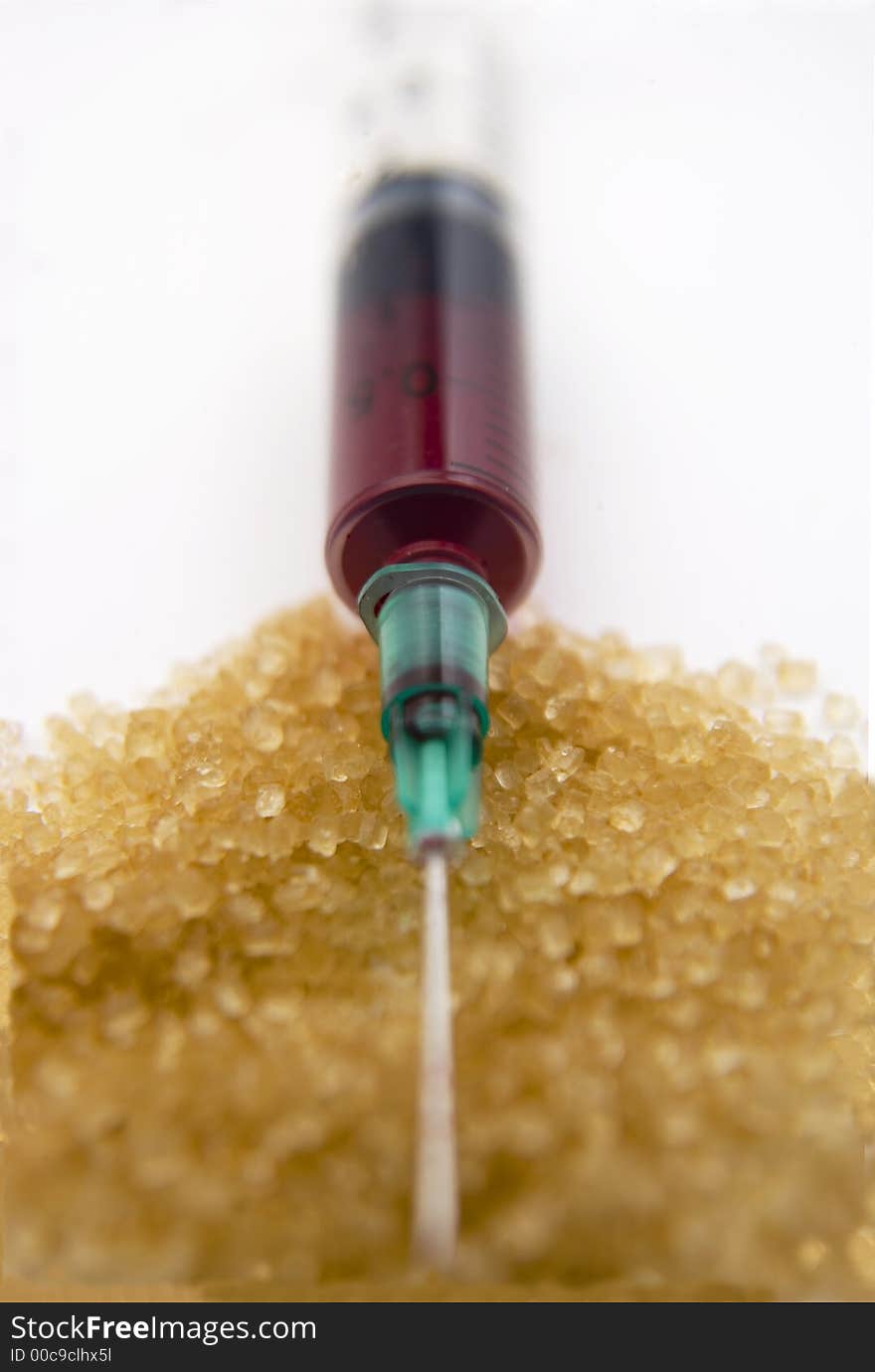 Blood filled hypodermic syringe on brown crystal foreground. Blood filled hypodermic syringe on brown crystal foreground