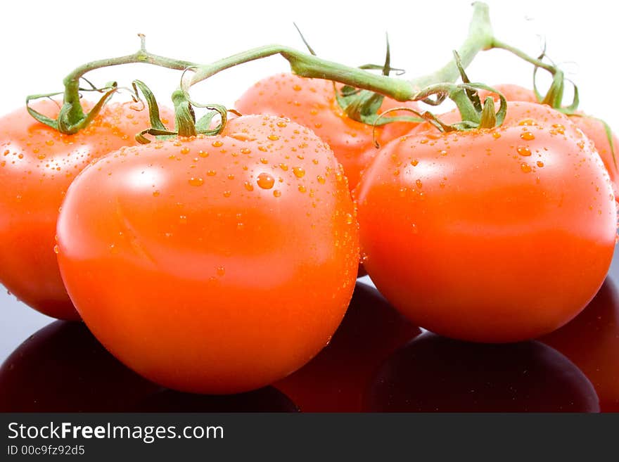 Bunch of tomatos on black plate tray, with white background. Bunch of tomatos on black plate tray, with white background