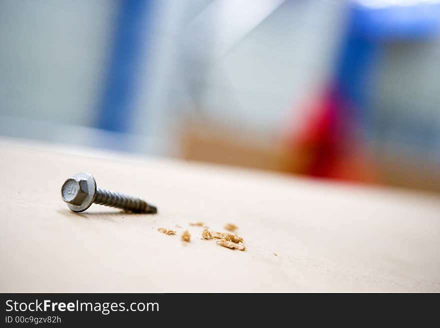 Screw on shelf with sawdust beautiful colors in background