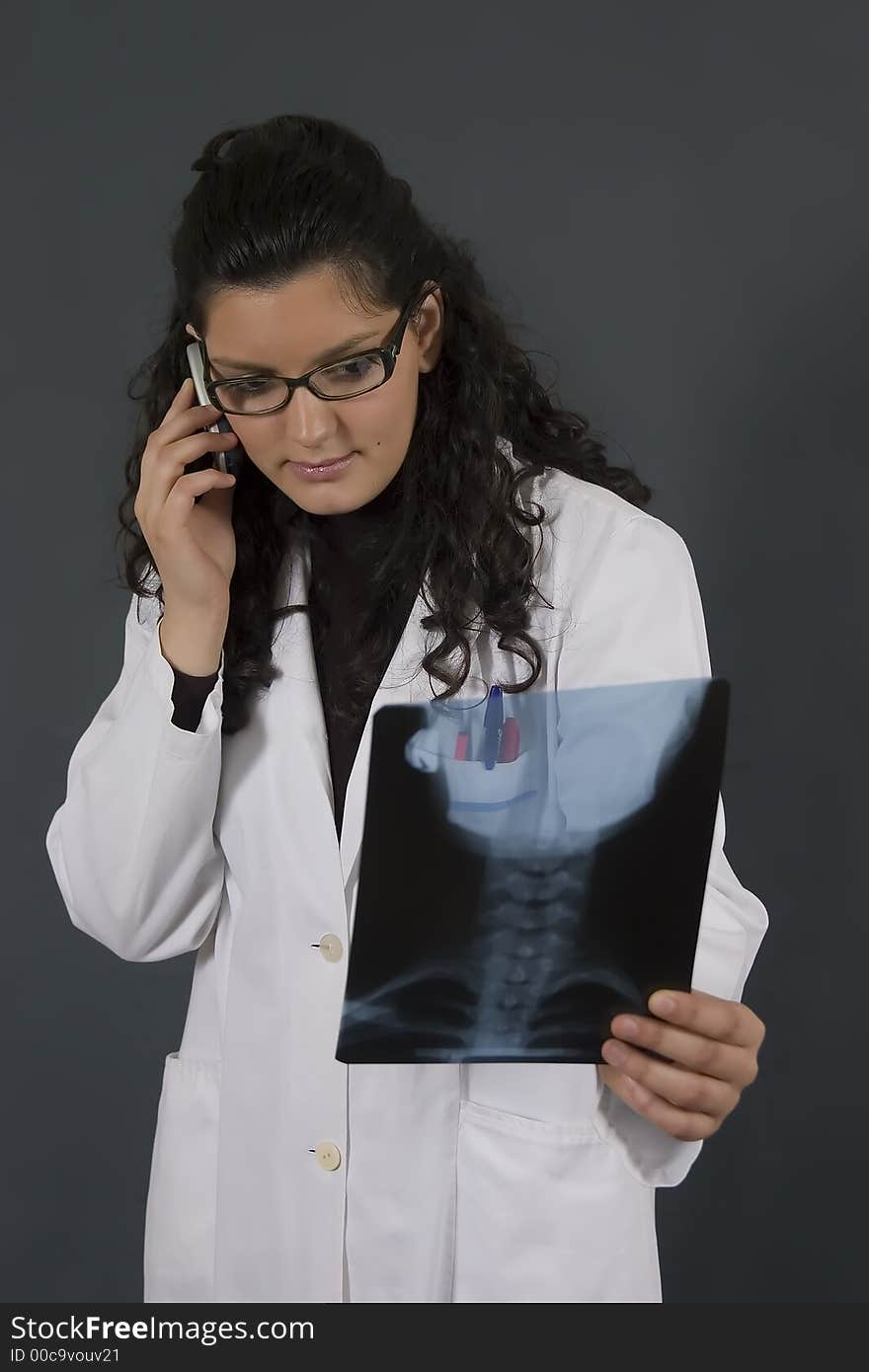 Young nurse analyzing a medical x-ray end talk on phone. Young nurse analyzing a medical x-ray end talk on phone