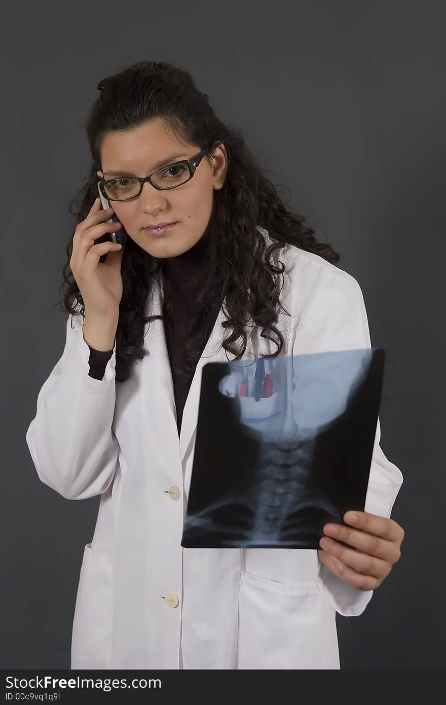 Young nurse analyzing a medical x-ray end talk on phone. Young nurse analyzing a medical x-ray end talk on phone