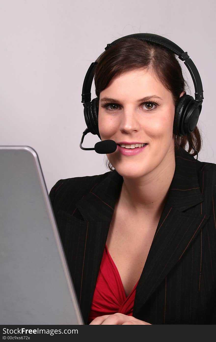 A young sexy operator in front of her laptop with a headset on. A young sexy operator in front of her laptop with a headset on.