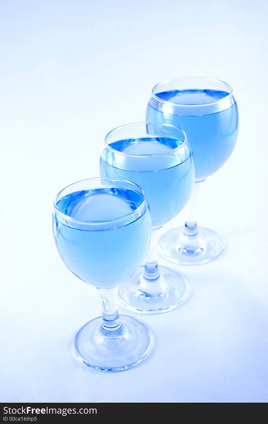 Glasses with a blue liquid on a white background