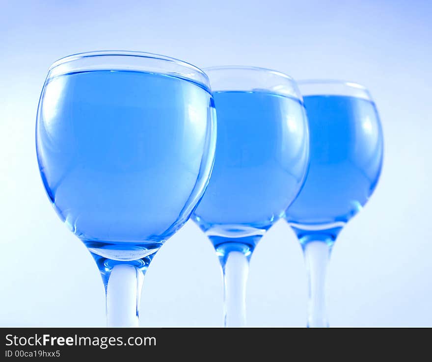 Glasses with a blue liquid on a white background