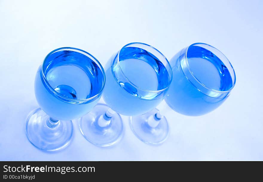 Glasses with a blue liquid on a white background