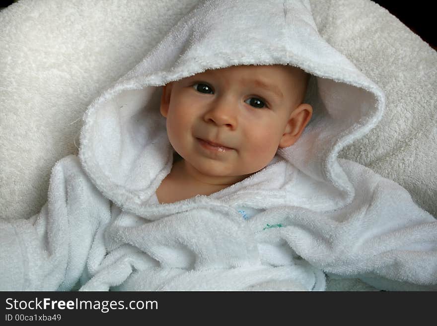 The baby of 7 months in sits in a dressing gown. The baby of 7 months in sits in a dressing gown