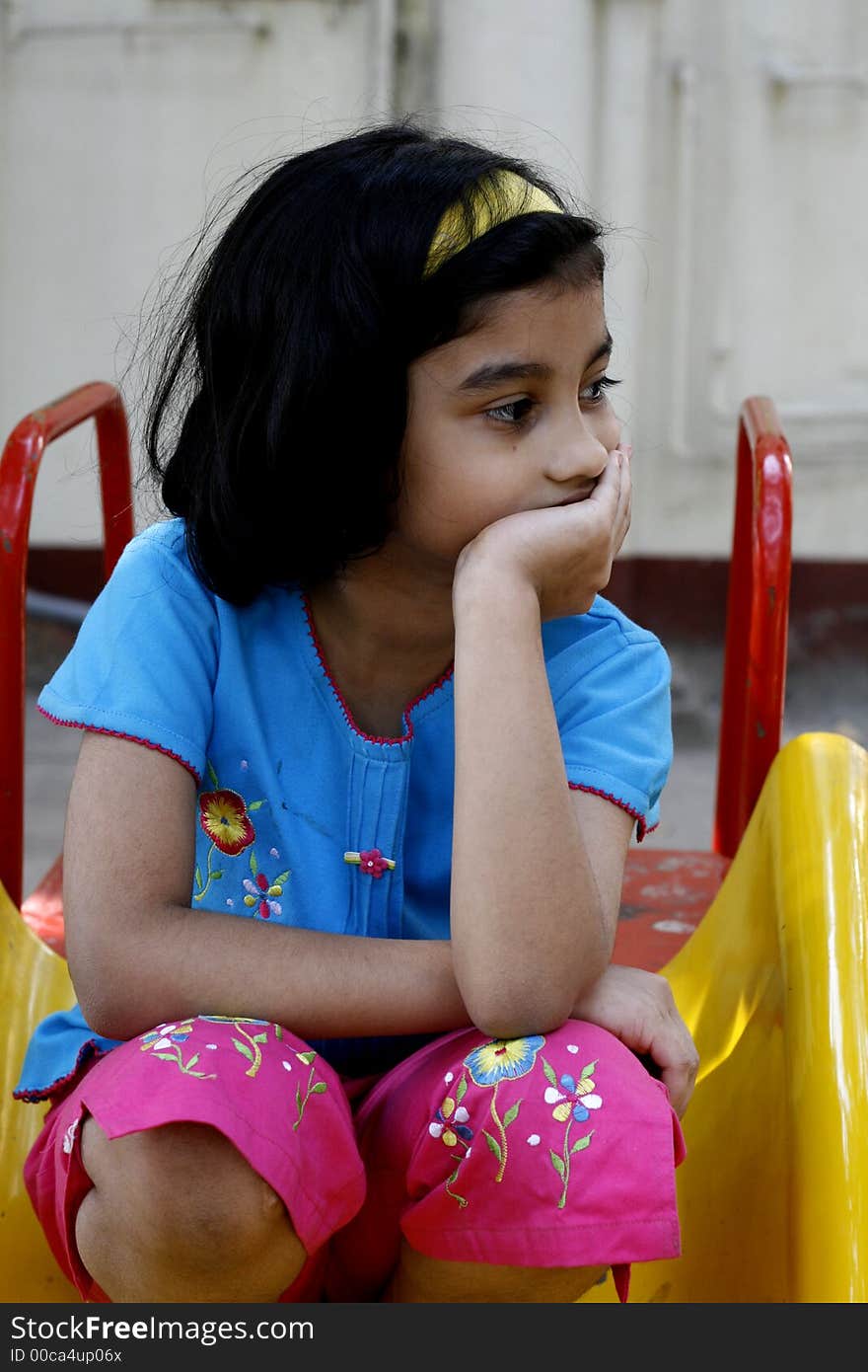 A girl sitting in the park engrossed in deep thoughts. A girl sitting in the park engrossed in deep thoughts.