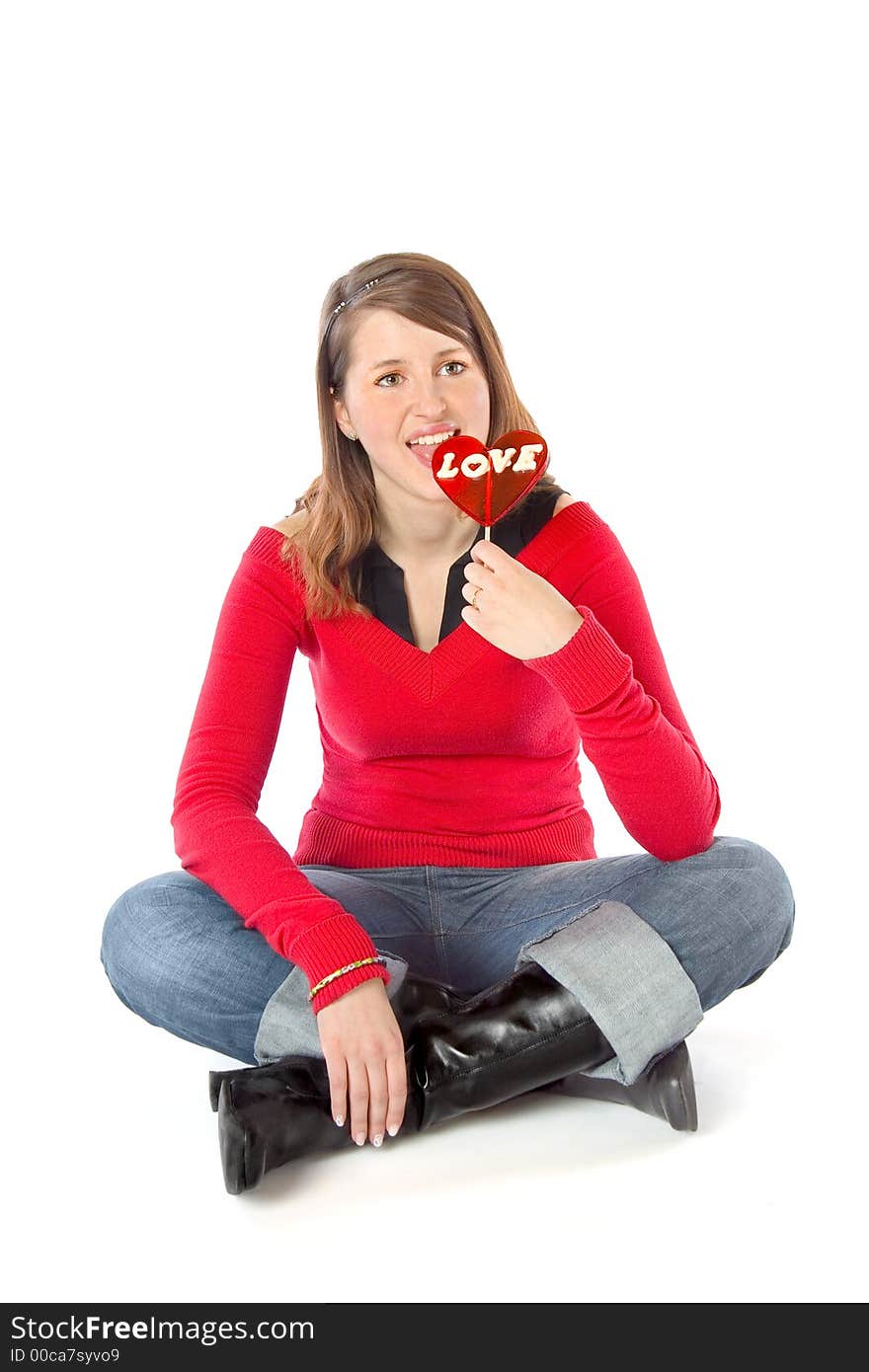 Young girl licking a big 'love' lollipop. Young girl licking a big 'love' lollipop.