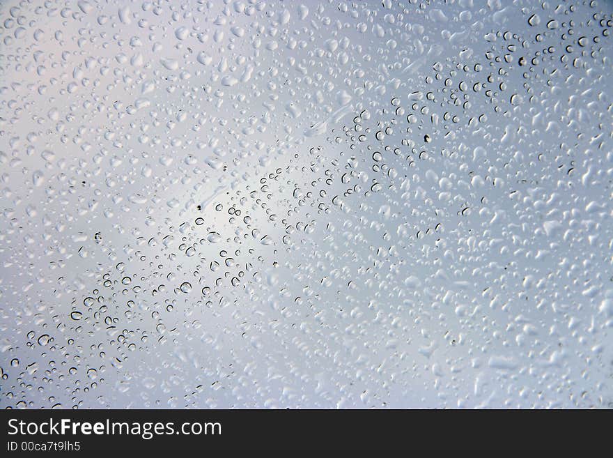 Background with drops of water on glass on a light background. Background with drops of water on glass on a light background.