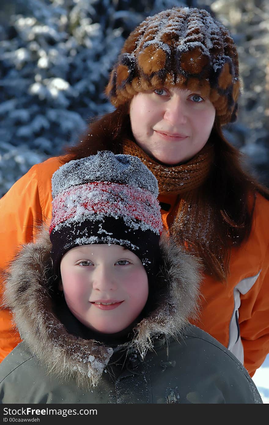 Portrait of mother and son in winter clothes and hats covered with snow taken in sunny , cold , winter day. Portrait of mother and son in winter clothes and hats covered with snow taken in sunny , cold , winter day