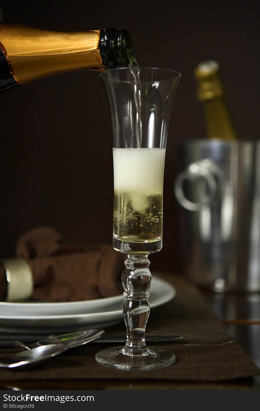 Pouring Champagne into a Champagne flute, or sparkling wine. Pouring Champagne into a Champagne flute, or sparkling wine