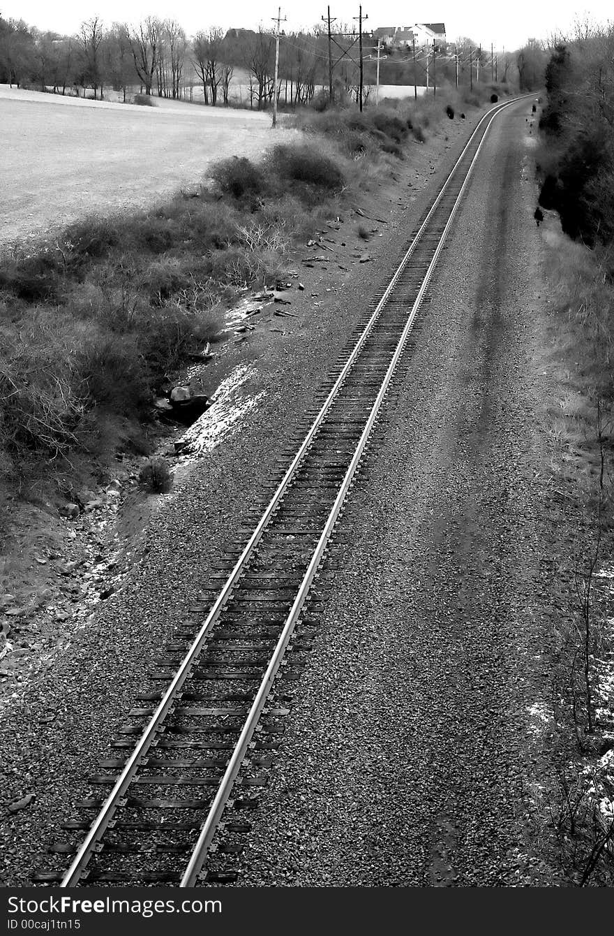 A black and white image of country railroad tracks.