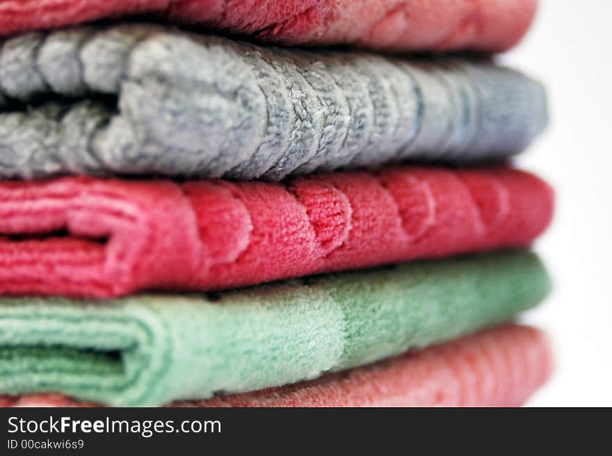 Bath towels of different colours piled on top of one another. Bath towels of different colours piled on top of one another