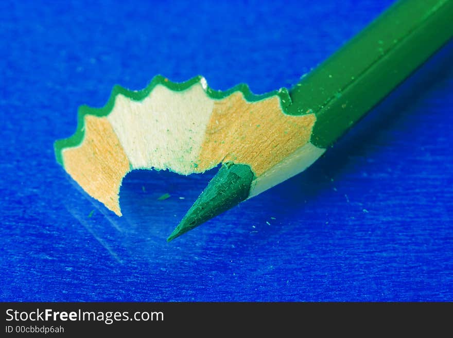 Green pencil over blue background. Green pencil over blue background