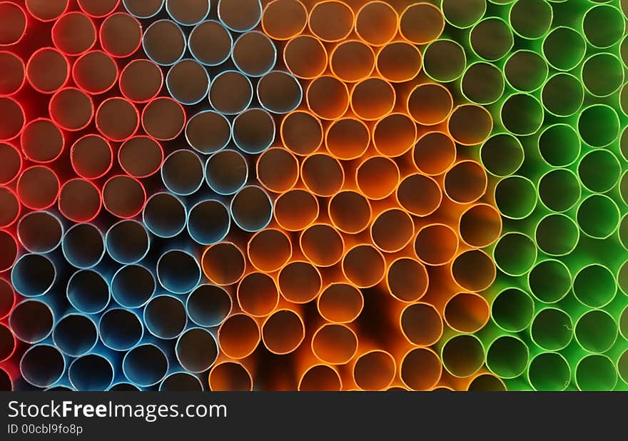 Macro shot of one end of drinking straws, a pack of red, green, blue and orange colored straws. Macro shot of one end of drinking straws, a pack of red, green, blue and orange colored straws