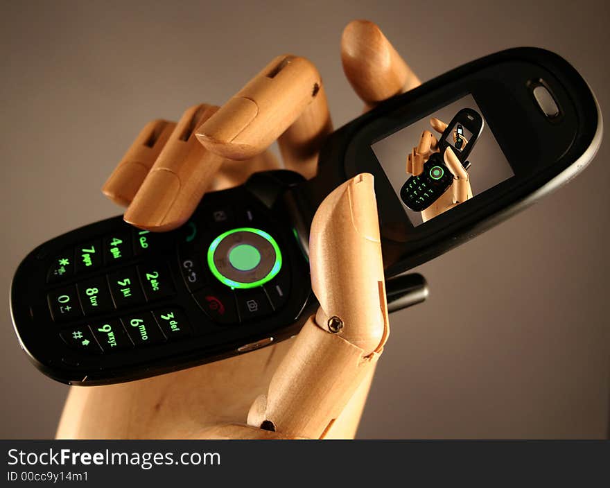 Cellular Phone in a wooden hand. Cellular Phone in a wooden hand.