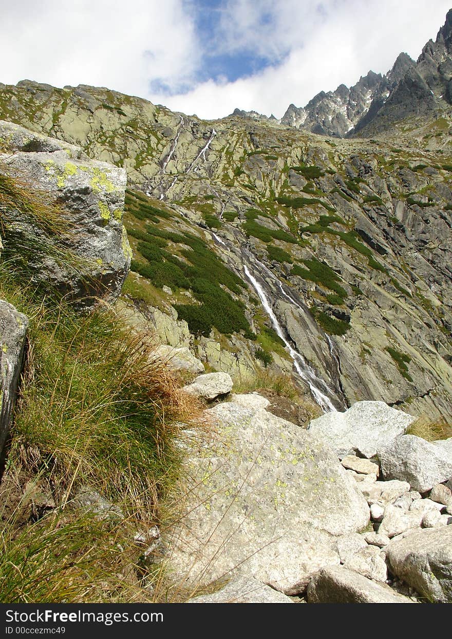 Waterfall at mountains with blue and clouds sky. Hihg Tatra. Waterfall at mountains with blue and clouds sky. Hihg Tatra