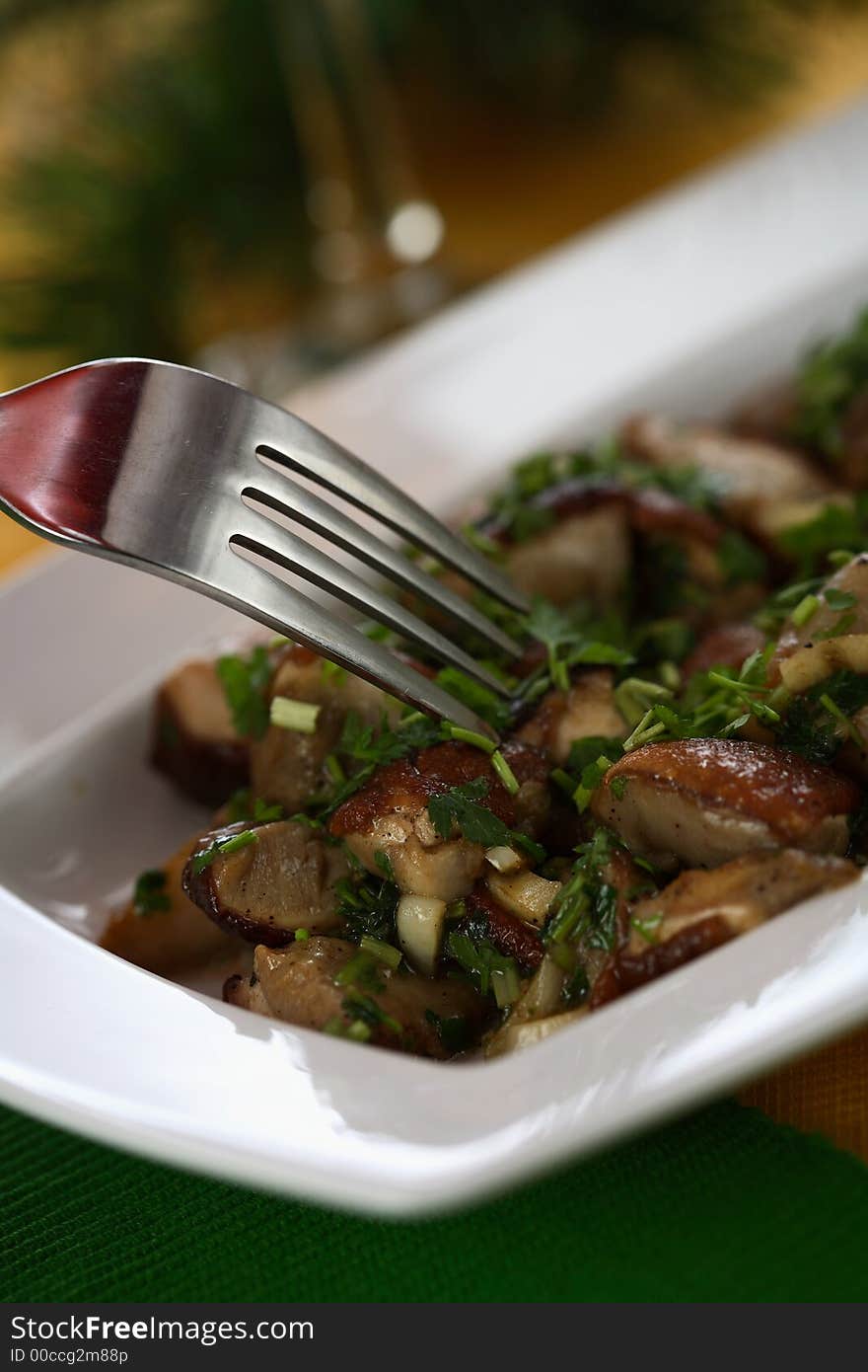 Boletuses in the cooking oil served with parsley. Boletuses in the cooking oil served with parsley