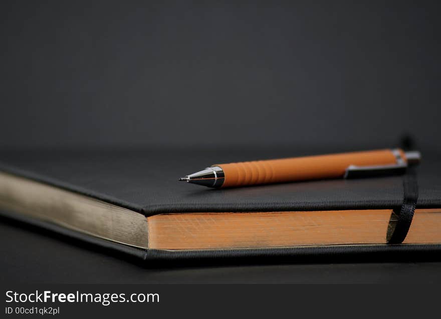 Writing Book With Orange Pencil